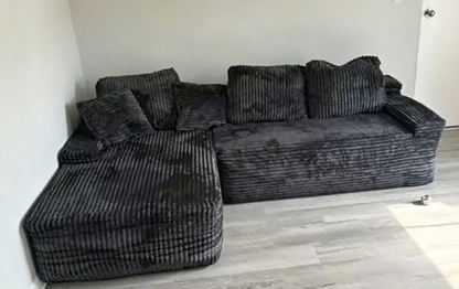 Vakuum komprimiertes 3-Sitzer Sofa in L-Form, ungeöffnet, mit schwarzem Bezug und modernen Design, bereit zum Aufbau.